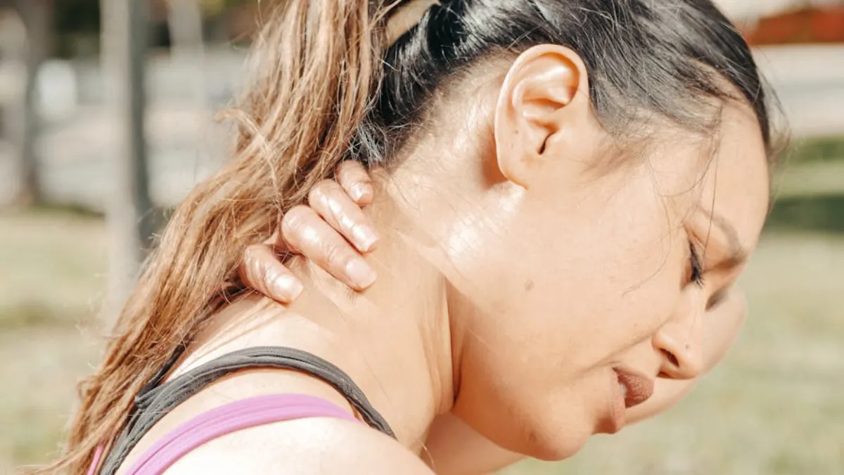 Person experiencing muscle tension and trigger point pain in neck and shoulders